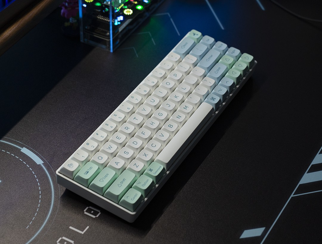 The Ice Mint keycap set installed on a compact board on a dark desk mat, lit from above